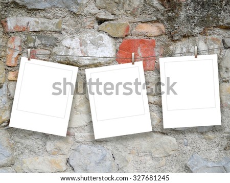 Three blank square instant photo frames on ancient cracked wall background