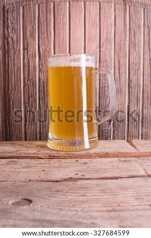 A glass of beer on a wooden background