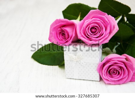 Pink  roses and gift box on a wooden background