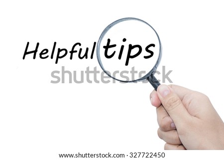 Hand Showing Helpful tips Word Through Magnifying Glass 