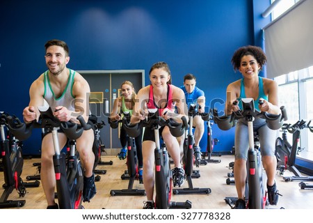 Fit people in a spin class the gym Royalty-Free Stock Photo #327778328