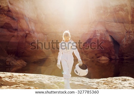 futuristic astronaut without a helmet in rays of another sun, image with the effect  toning Royalty-Free Stock Photo #327785360