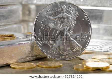 United States Silver Eagle with Gold coins & silver bars in background Royalty-Free Stock Photo #327814202