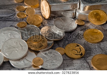 Gold & Silver Coins with Silver Bars on map Royalty-Free Stock Photo #327823856