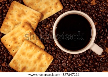 cup of coffee, coffee beans,cracker background.
