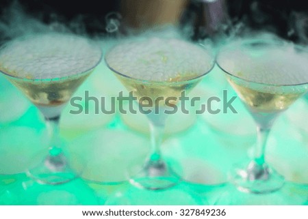 Beautiful row line of different colored alcohol cocktails with mint on a open air party, martini, vodka with bubbles,and others on decorated catering bouquet table on open air event, picture 