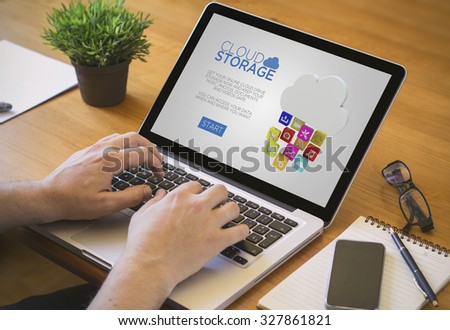 Businessman at work. Close-up top view of man with cloud storage website on laptop. all screen graphics are made up.