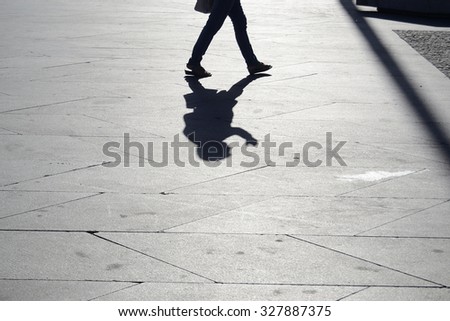 shadow of a walking person on the floor Royalty-Free Stock Photo #327887375