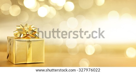 Golden gift box on abstract background Royalty-Free Stock Photo #327976022