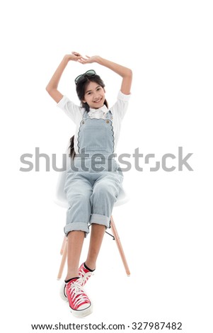 Asian teenage girl smiling sitting on chair with white background.