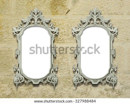 Two baroque decorated picture frames on old yellow wall background