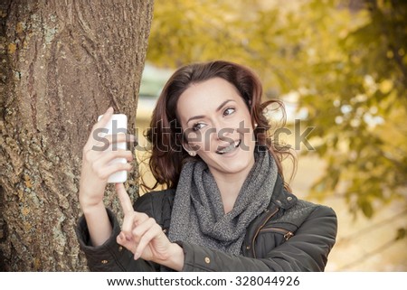 Young woman out on a walk taking pictures and self portraits on her smartphone