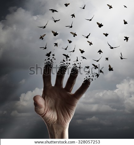 Life transformation concept as a hand reaching out transforming into flying birds following sunlight as a freedom symbol of hope renewal and spirituality or human faith. Royalty-Free Stock Photo #328057253