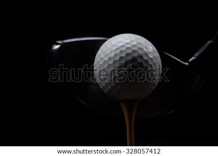 Teeing off/Golf ball club and tee on black background