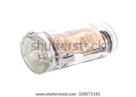 Money Indian Currency Rupee Notes and Coins in a glass jar isolated