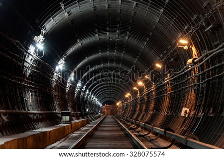 Straight circular subway tunnel with tubing and two different lights: white and yellow Royalty-Free Stock Photo #328075574