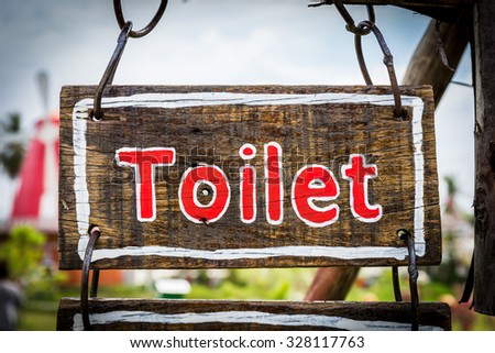 Sign with Toilet text on wood plate