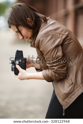 Woman photographer with an old vintage medium format camera. Shallow depth of field. Selective focus on model.