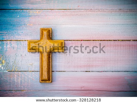 wooden cross on colorful painted  wooden texture background
