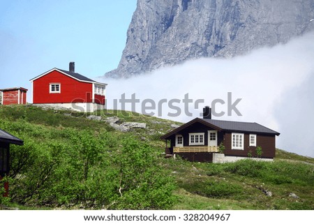 Color image of a rustic wooden house in the mountains.