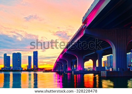 Miami Florida at sunset, colorful skyline of illuminated buildings and Macarthur causeway bridge