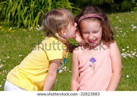 Two girls whispering secrets to each other