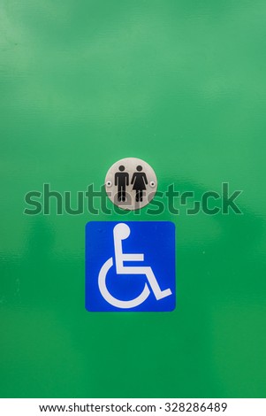 Disabled toilet sign, against a green background