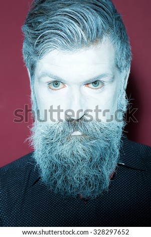 Portrait closeup view of one halloween holiday celebration character senior man with spooky painted face of zombi and long white lush beard looking forward on purple background, vertical picture