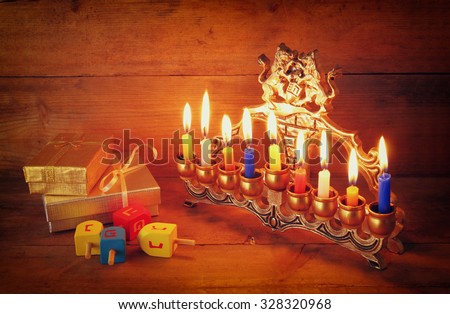 low key image of jewish holiday Hanukkah with menorah (traditional Candelabra) and wooden dreidels (spinning top)
