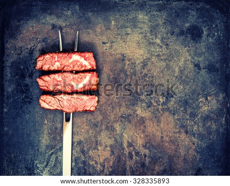 Grilled beef meat on rustic metal background. Food concept. Vintage style toned picture