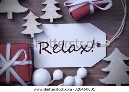 Black and White Close Up Of Label With Ribbon,Red Gift,Present, Ribbon And Tree. Christmas Decoration Or Card On Wooden Background. English Text Relax