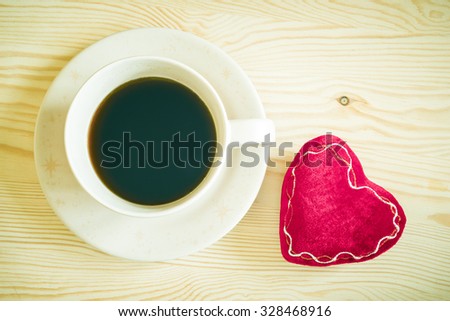 coffee cup and red heart on wooden table + vintage filter