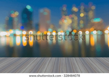 Opening wooden floor, abstract blurred bokeh city lights at night with water reflection