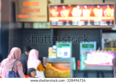 Blur image of people queue for popcorn before watching cinema.