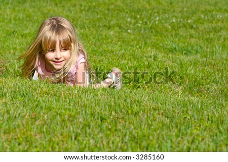 Adorable little girl playing in a field of grass