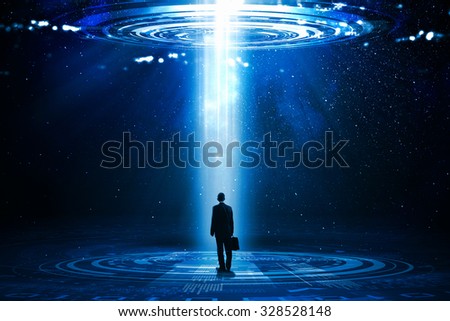 Rear view of businessman standing in light going from above