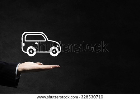 Hand of businessman with car against gray background