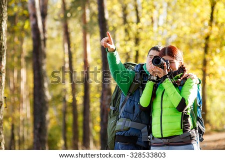 woman photographer takes pictures with man in park