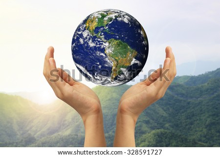 Hand holding the blue Earth. Elements of this image furnished by NASA