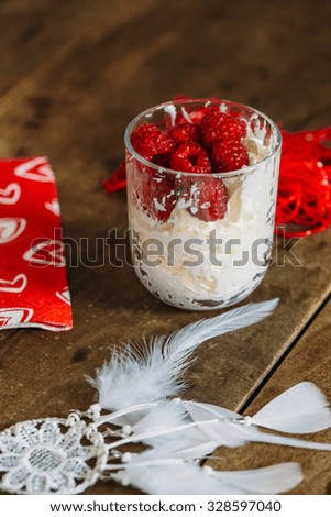 cream and raspberries on wooden background