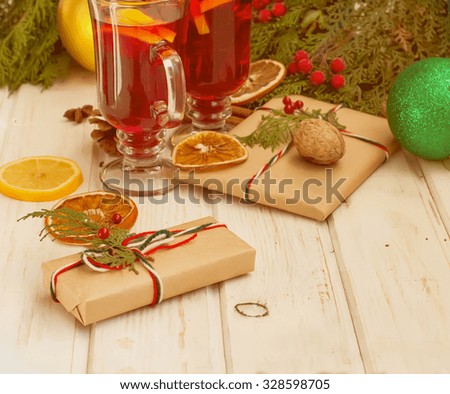 Mulled wine with cinnamon and star anise with slice of orange and spices and Christmas cakes, with decorated background