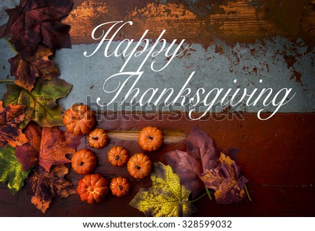 Happy Thanksgiving on wooden vintage board with pumpkins and leaves