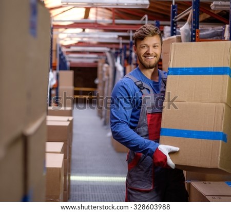 Porter carrying boxes in a warehouse  Royalty-Free Stock Photo #328603988