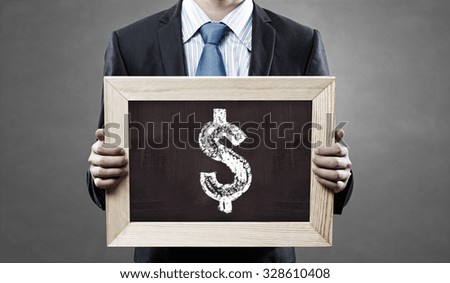 Unrecognizable businessman holding blackboard with drawn dollar concept