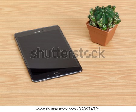 Black electronic device, tablet pc on wooden table