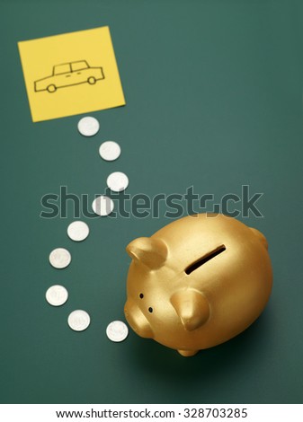 Dream car savings - golden piggy bank, coins and car sketch on blackboard