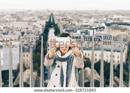 Young attractive girl making a self-portrait picture with panoramic view of Paris