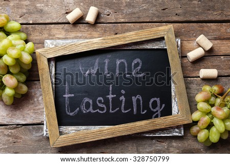 Old chalk scripted frame with grape on wooden background