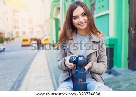 Happy woman on vacation photographing with a dslr camera on the city street