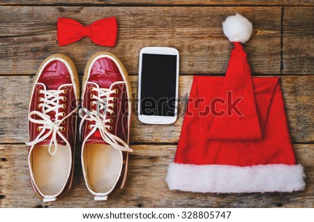 wood background with phone sneakers red hood and a bow. toning. selective focus
